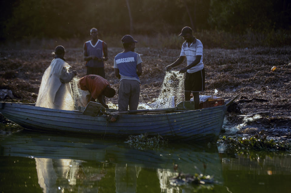 Fishermen sort their tangled nets at sunset on Lake Chivero, west of the capital Harare, in Zimbabwe Tuesday, Sept. 10, 2019. Former president Robert Mugabe, who enjoyed strong backing from Zimbabwe's people after taking over in 1980 but whose support waned following decades of repression, economic mismanagement and allegations of election-rigging, is expected to be buried on Sunday, state media reported. (AP Photo/Ben Curtis)