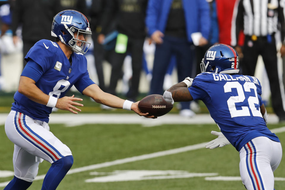 New York Giants quarterback Daniel Jones (8) hands off the ball to running back Wayne Gallman (22) during the first half of NFL football game against the Cincinnati Bengals, Sunday, Nov. 29, 2020, in Cincinnati. (AP Photo/Aaron Doster)