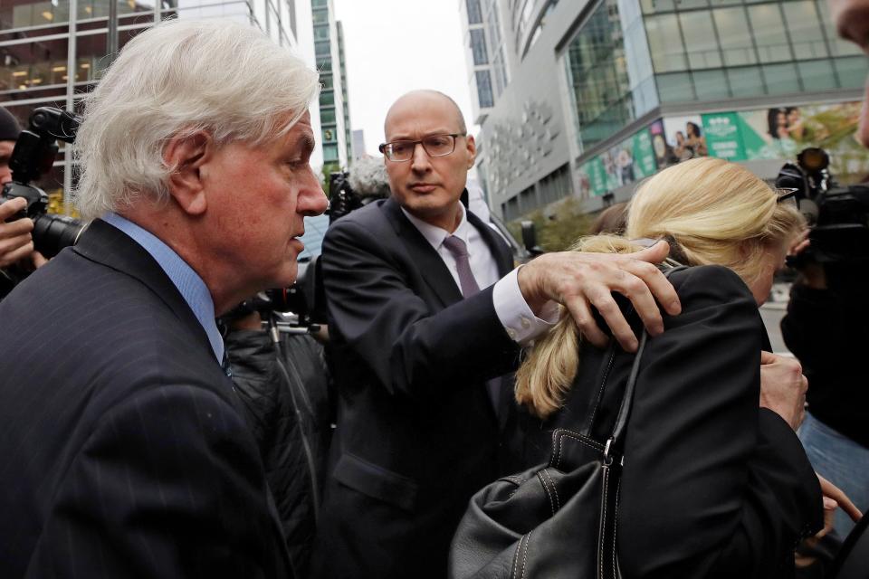 Gregory Abbott, far left, and his wife Marcia, far right, get into a car as they leave federal court after their sentencing in a nationwide college admissions bribery scandal, Tuesday, Oct. 8, 2019, in Boston.