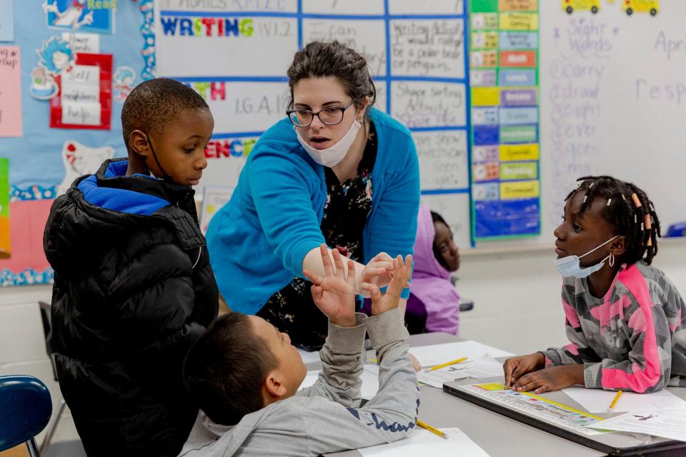 A teacher helps a second grader count on his fingers during a math lesson at an after school tutoring program at Ecorse Ralph J. Bunche Elementary School on April 7, 2022, in Ecorse, Michigan.