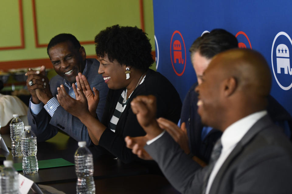 Jennifer-Ruth Green, the Republican candidate for Indiana's 1st Congressional District and an U.S. Air Force veteran, second from left, along with U.S. Sen. Todd Young (R-Ind.), second from right, and Rep. Burgess Owens (R-UT.), left, react to business owner Sean Jointer, right, speaking during a roundtable meeting Thursday, Oct. 20, 2022, in Gary, Ind. (AP Photo/Paul Beaty)