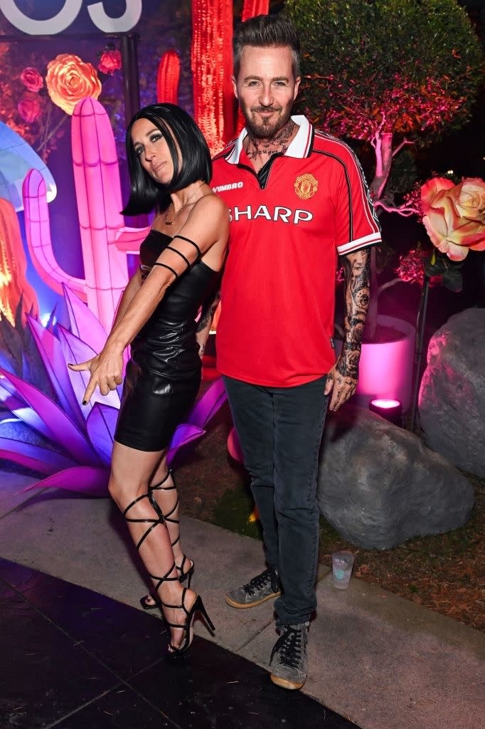 she's in a tight mini leather dress and he's in jeans, fake tattoos, and a soccer jersey