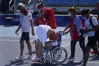 Paula Badosa, of Spain, is helped off the court in a wheelchair after retiring due to illness during the quarterfinals of the tennis competition at the 2020 Summer Olympics, Wednesday, July 28, 2021, in Tokyo, Japan. (AP Photo/Seth Wenig)