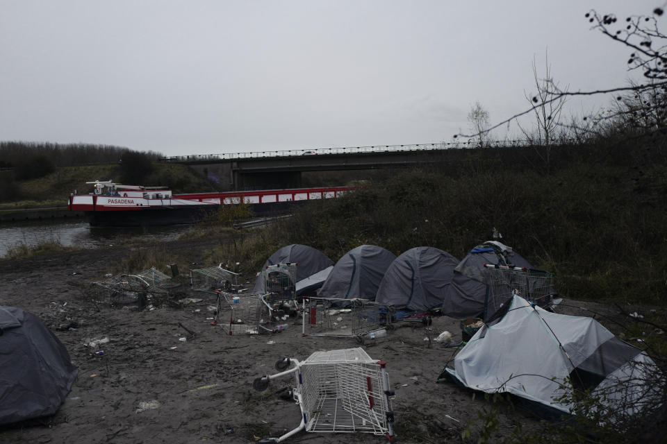 A migrants makeshift camp is set up along the river in Loon Plage, near Grande-Synthe, northern France, Friday, Nov. 26, 2021. Children and pregnant women were among at least 27 migrants who died when their small boat sank in an attempted crossing of the English Channel, a French government official said Thursday. (AP Photo/Rafael Yaghobzadeh)