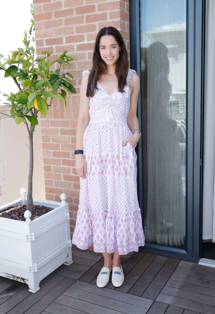 christina schwarzenegger smiling for a photo next to a plant