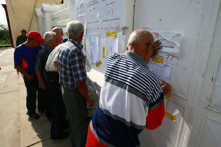 People check the information on a polling station during a nationwide election for new governors in Maracaibo, Venezuela, October 15, 2017. REUTERS/Jose Issac Bula Urrutia
