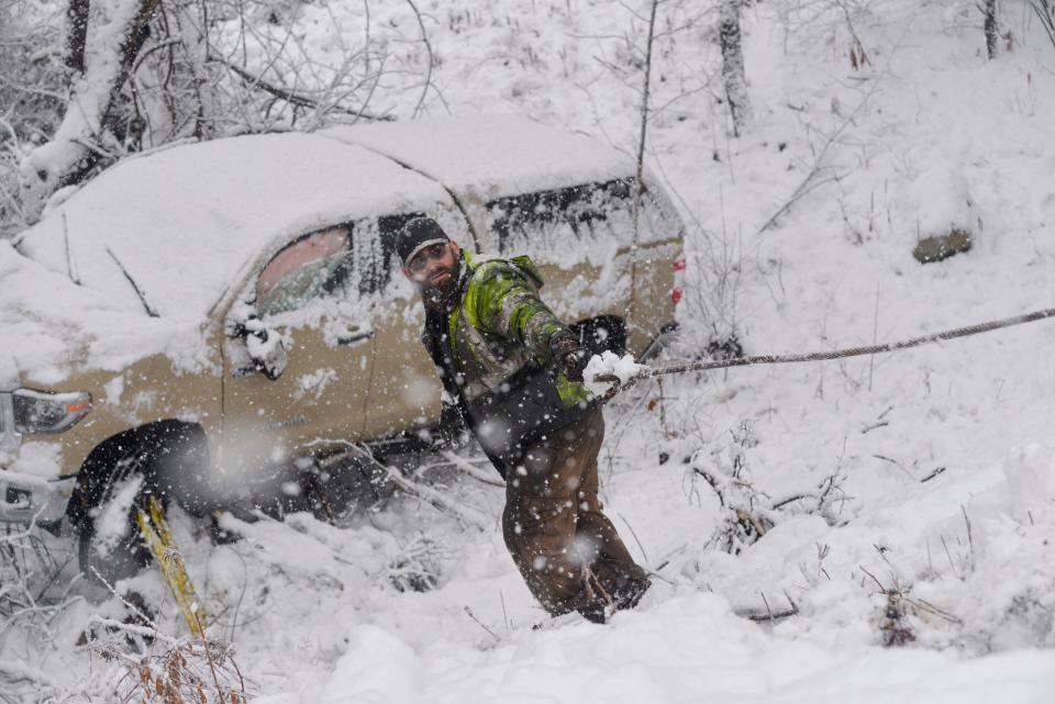 A crew from A's Auto and Truck Repair in Guilford helps clean up one of the two three-vehicle crashes along Route 30 in Jamaica, Vt., during a snowstorm on Friday, Dec. 16, 2022.