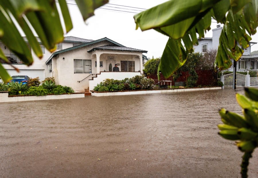 A resident watches as floodwaters rise during a rainstorm, Sunday, Feb. 4, 2024, in Santa Barbara, Calif. (AP Photo/Ethan Swope)