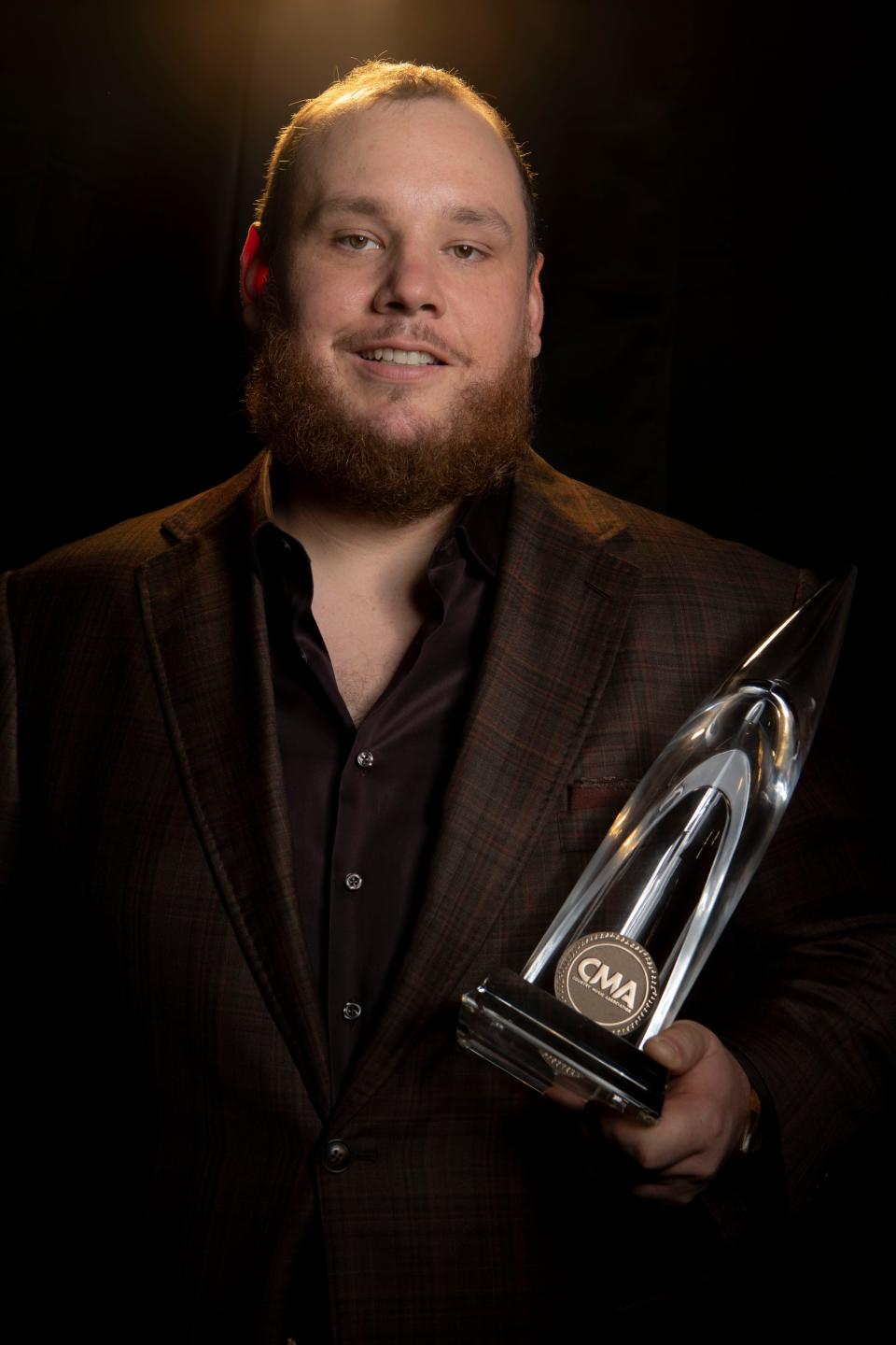 Luke Combs stands backstage holding his CMA award for Single of the Year, at Bridgestone Arena in Nashville, Tenn., Thursday, Nov. 8, 2023.