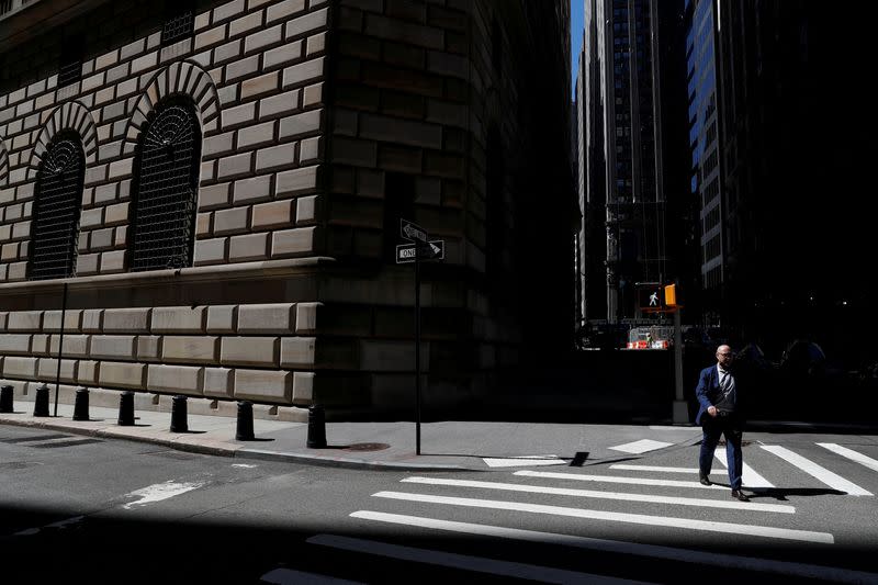 FILE PHOTO: A man walks by the Federal Reserve Bank of New York Building in New York City