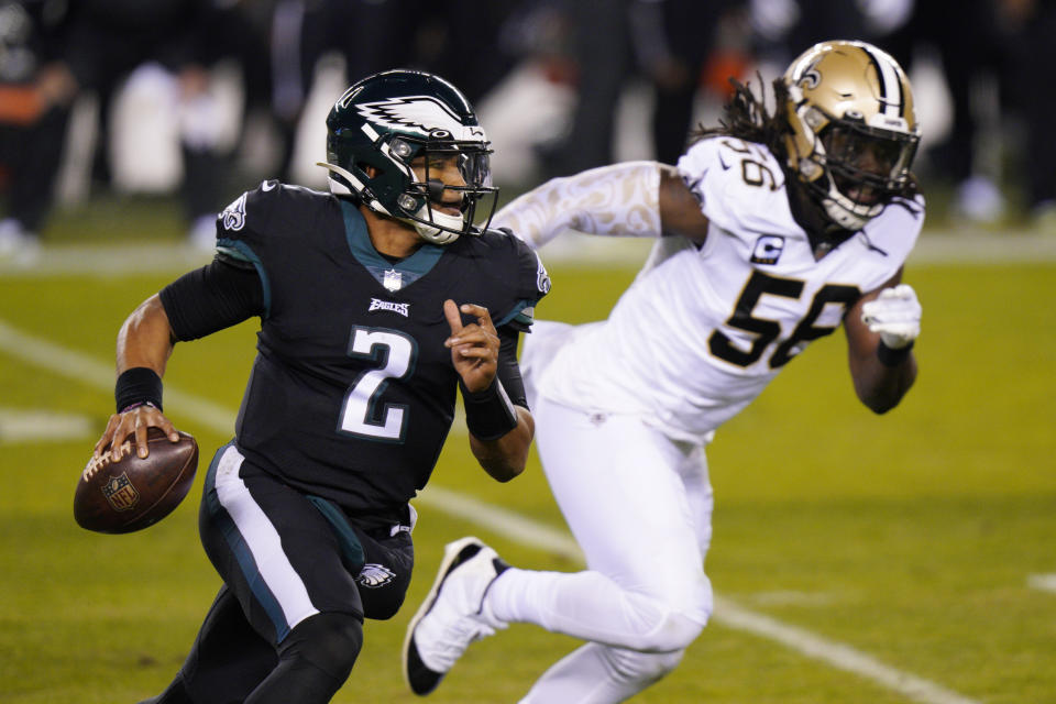 Philadelphia Eagles' Jalen Hurts, left, scrambles past New Orleans Saints' Demario Davis. (AP Photo/Chris Szagola)