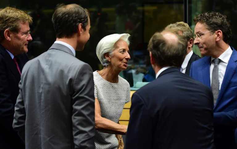 Managing Director of the International Monetary Fund Christine Lagarde (C) greets President of the Eurogroup Jeroen Dijsselbloem (R) prior to a meeting of the Eurogroup finance ministers in Brussels on July 11, 2015