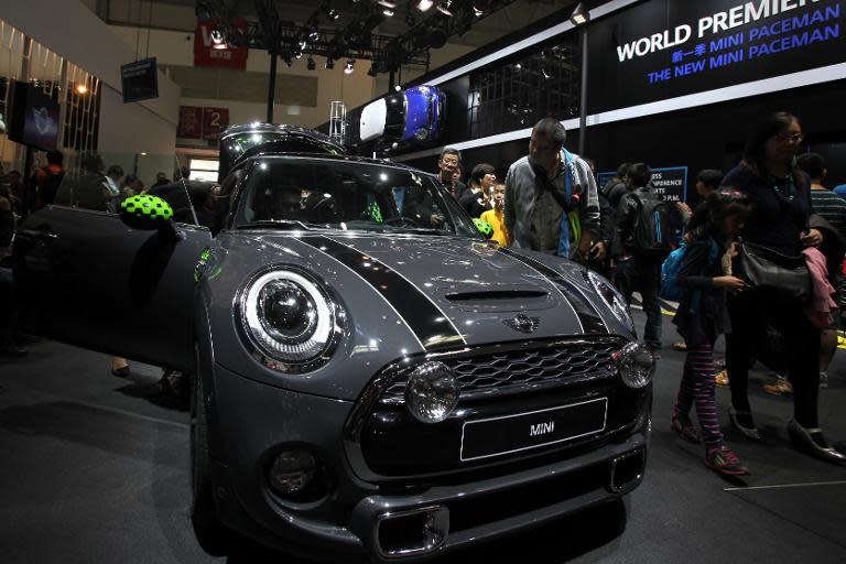 Visitors check out a BMW mini car at the Beijing International Automotive Exhibition on April 20, 2014