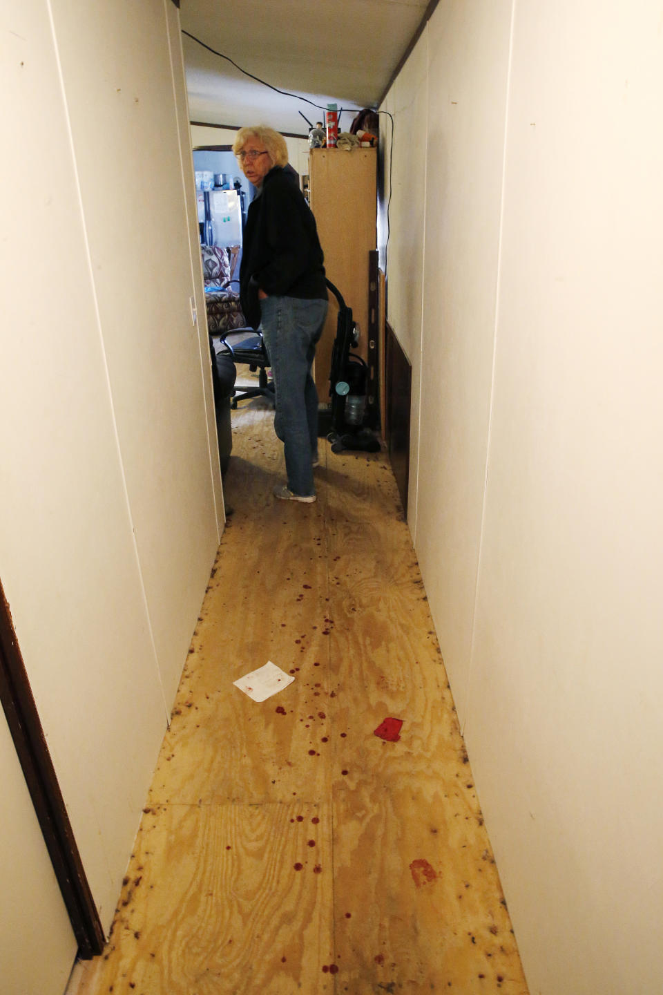 EDS NOTE: GRAPHIC CONTENT - Kim Mincks walks down a blood stained hallway inside her home in Gonzalez, La., Sunday, Jan. 27, 2019, where two of her housemates, Keith Theriot and his wife Elizabeth Theriot, were killed in another room yesterday while she slept. (AP Photo/Gerald Herbert)