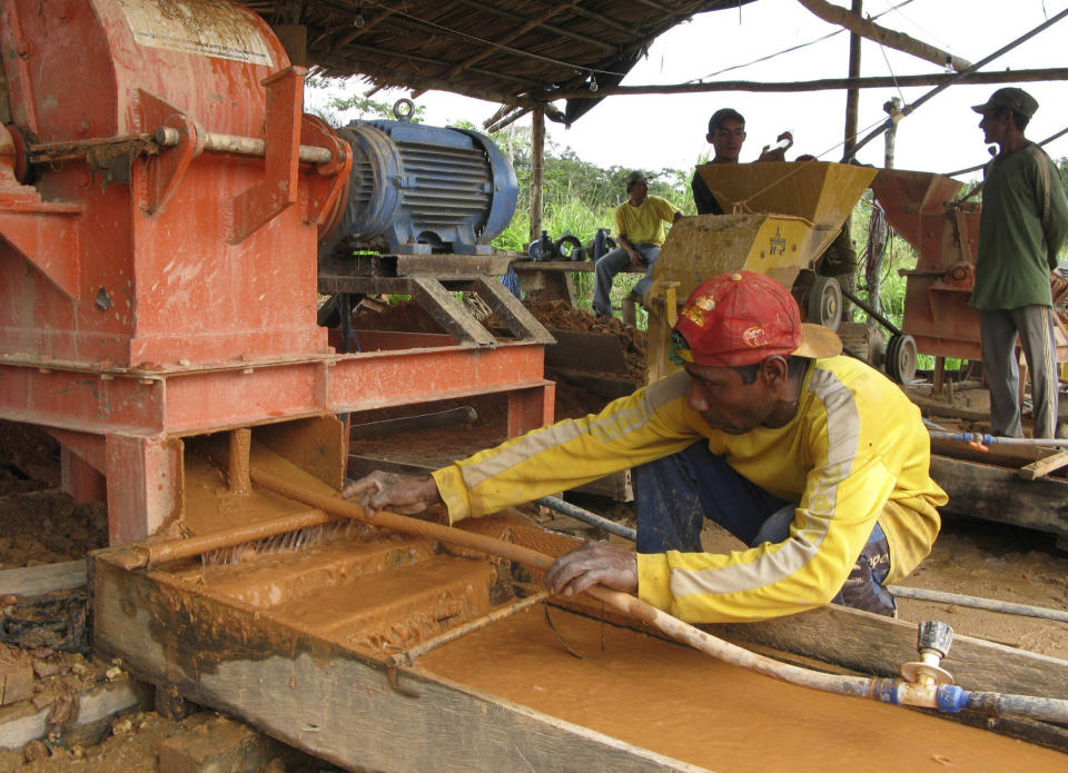 A Brazilian gold miner cleans a rock crusher in Bom Jesus along the Tapaj&acute;s River. (Photo: Staff Photographer/Reuters)