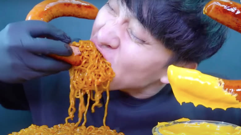 man eating sausages and noodles