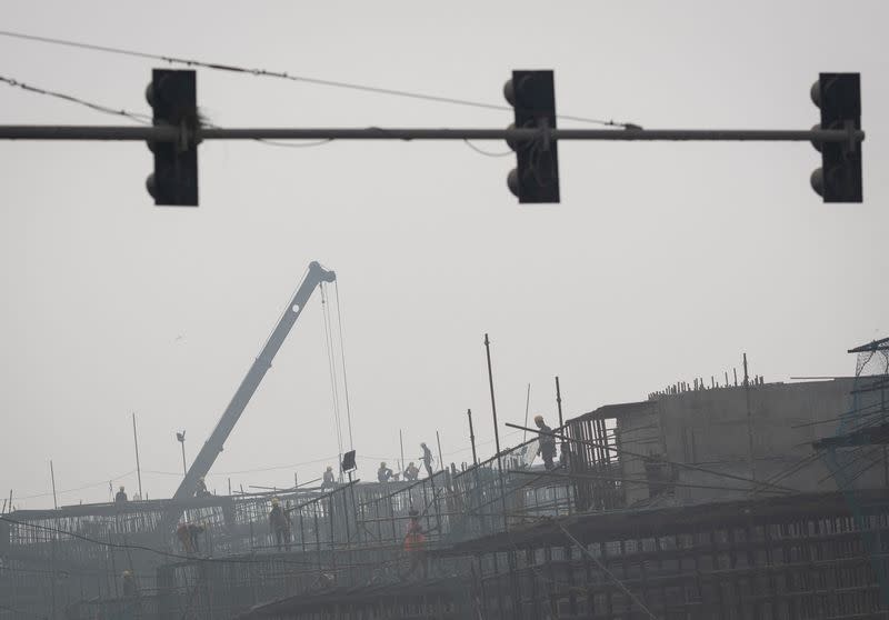 Labourers work at a construction site of a flyover amidst heavy smog in New Delhi