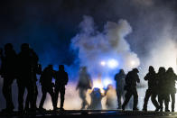 Authorities fire gas munitions at demonstrators gathered outside the Brooklyn Center Police Department to protest the shooting death of Daunte Wright, late Tuesday, April 13, 2021, in Brooklyn Center, Minn. (AP Photo/John Minchillo)