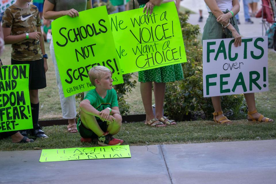 Grayson Bair, 9, from Highland Park Elementary in Gilbert, Ariz., attends  the "AZ Open Our Schools Rally" with his family at the state Capitol In Phoenix.