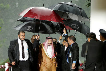 Saudi Arabia's King Salman and Indonesian President Joko Widodo walk under umbrellas in heavy rain upon arrival at the Presidential Palace in Bogor, West Java, Indonesia March 1, 2017. REUTERS/Achmad Ibrahim