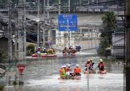 <p>Rescuers on boats head for search in the partly submerged area in water after heavy rain in Kurashiki city, Okayama prefecture, southwestern Japan, July 8, 2018. Heavy rainfall hammered southern Japan for the third day, prompting new disaster warnings on Kyushu and Shikoku islands Sunday. (Photo: Koji Harada/Kyodo News via AP) </p>