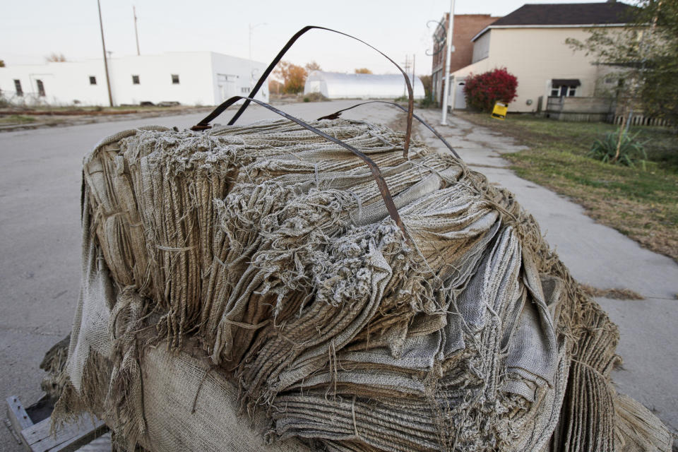 In this Oct. 24, 2019 photo, burlap bags for sandbagging remain on a street following flooding in Winslow, Neb. It took only minutes for swift-moving floods from the Elkhorn River to ravage tiny Winslow this spring, leaving nearly all its 48 homes and businesses uninhabitable. Now, the couple dozen residents still determined to call the place home are facing a new challenge: Moving the entire town several miles away to higher ground. (AP Photo/Nati Harnik)