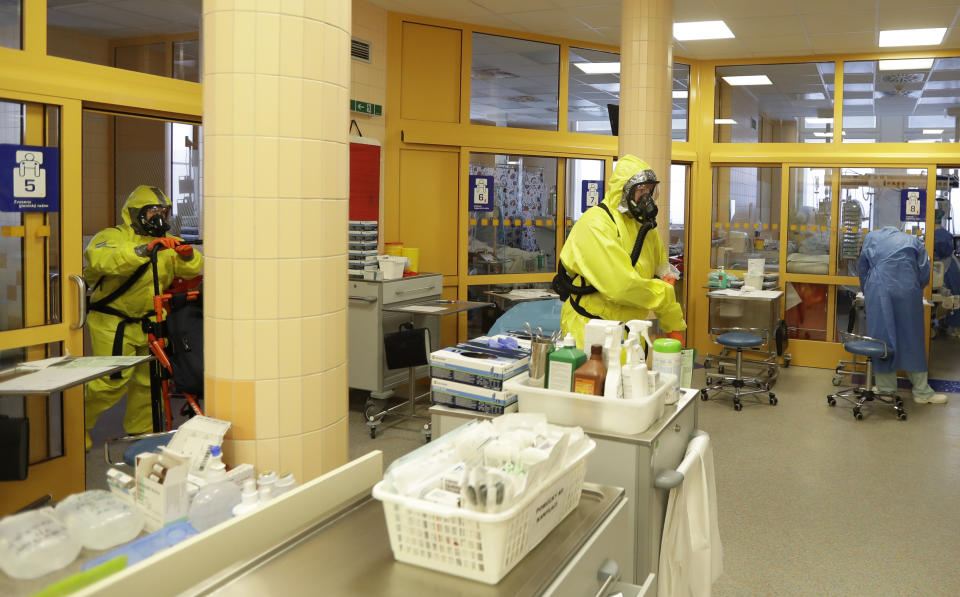 Paramedics in protective gear walk through an intensive care unit (ICU) after bringing in a new COVID-19 patient into the General University Hospital in Prague, Czech Republic, Tuesday, April 7, 2020. The new coronavirus causes mild or moderate symptoms for most people, but for some, especially older adults and people with existing health problems, it can cause more severe illness or death. (AP Photo/Petr David Josek)