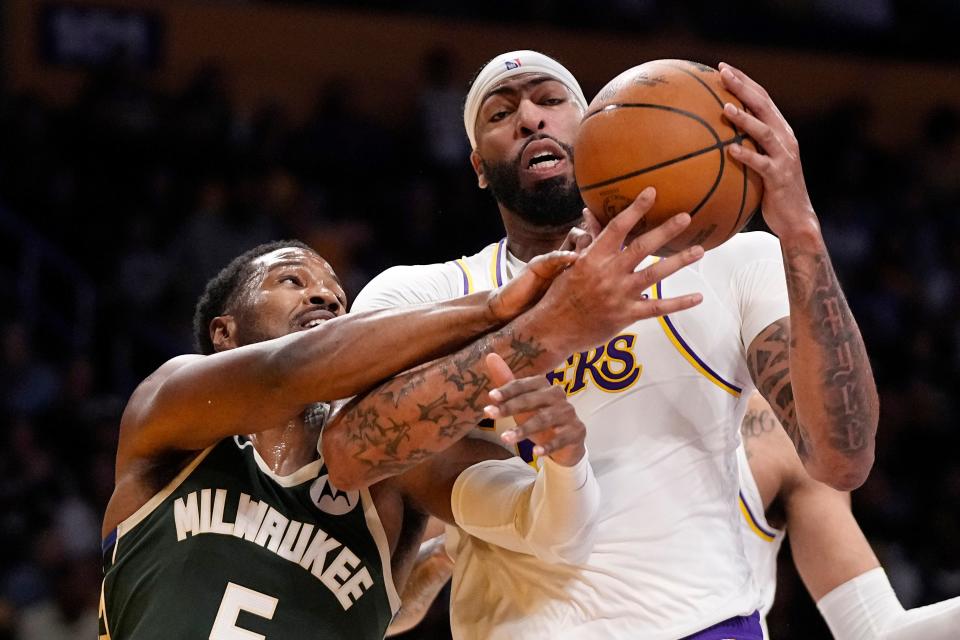 Bucks guard Malik Beasley, left, reaches for the ball against Lakers forward Anthony Davis during the preseason on Oct. 15.