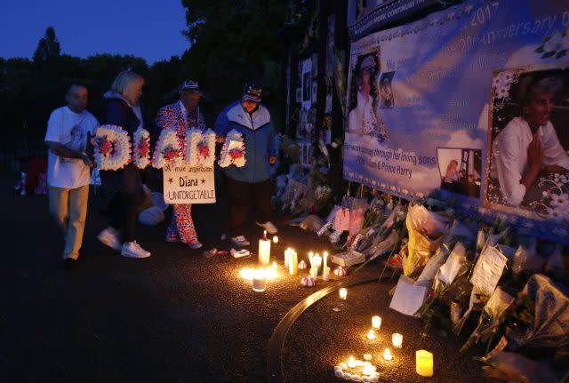 Tributes, candles and flowers are laid by royal fans outside Kensington Palace (Alastair Grant/AP)