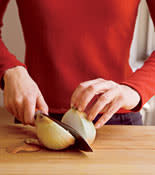 2. Stand the onion upright and cut in half, through the center of the root.