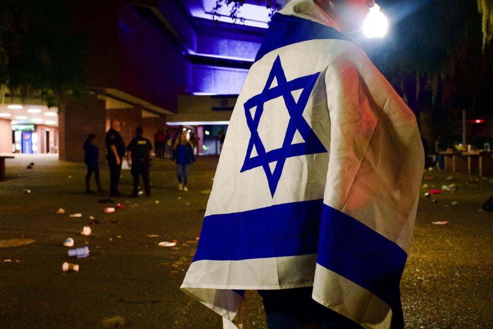 A student stands over in an emptied Turlington Plaza Monday night, Oct. 9, 2023 after a scare caused hundreds of students to run from a candle vigil supporting Israel following the Pakistan and Israel attacks.