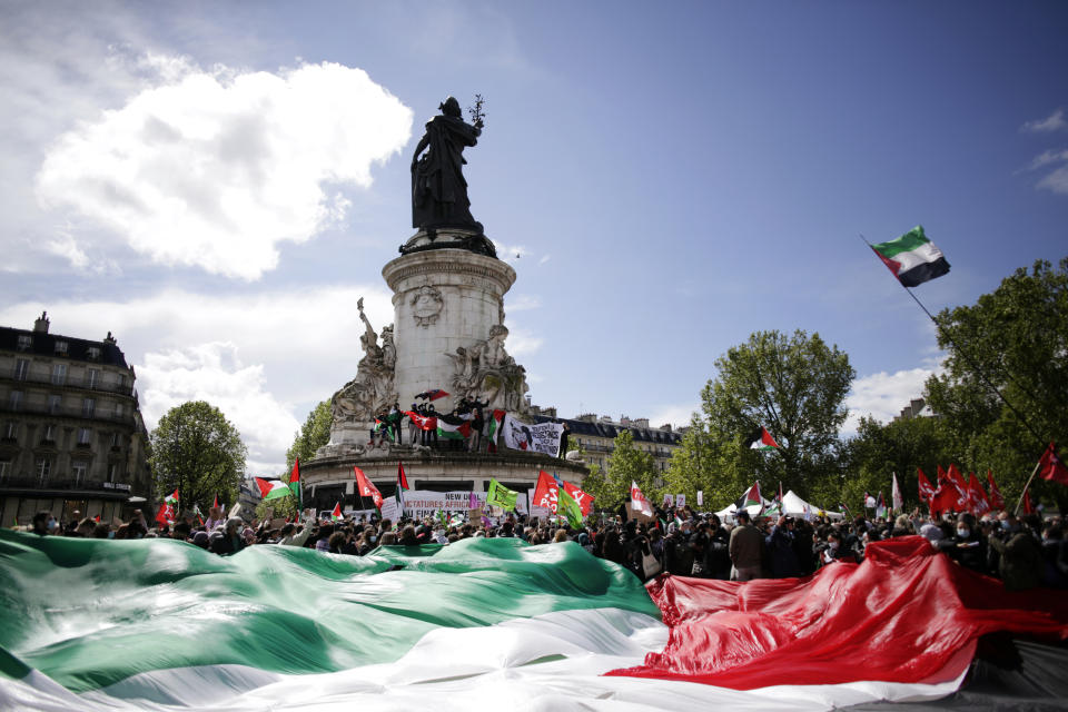 Protesters hold a giant Palestinian flag in Paris, Saturday, May 22, 2021, as they take part in a rally supporting Palestinians. Egyptian mediators held talks Saturday to firm up an Israel-Hamas cease-fire as Palestinians in the Hamas-ruled Gaza Strip began to assess the damage from 11 days of intense Israeli bombardment.Supporters of the Palestinians. (AP Photo/Thibault Camus)