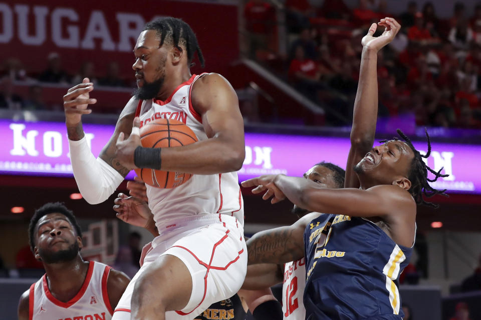 Houston forward J'Wan Roberts, front left, pulls down a rebound in front of Northern Colorado forward Bryce Kennedy, right, during the first half of an NCAA college basketball game Monday, Nov. 7, 2022, in Houston. (AP Photo/Michael Wyke)
