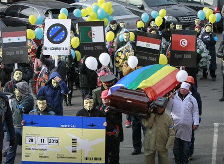 People dressed in outfits of various popular professions in Ukraine carry a coffin symbolising Ukraine's Euro-association and an airplane ticket back to Brussels to the EU Delegation building in Ukraine during a symbolic funeral procession and an anti-Europe rally in Kiev November 28, 2013. REUTERS/Gleb Garanich