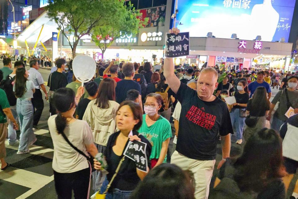 「高雄大路過」外國人安靜舉牌方式表達訴求。(記者黃富貴攝)