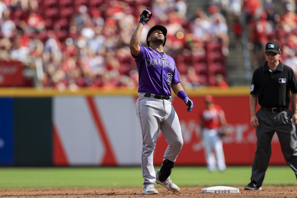 Colorado Rockies' Elias Diaz reacts after hitting an RBI-double during the second inning of a baseball game against the Cincinnati Reds in Cincinnati, Saturday, June 12, 2021. (AP Photo/Aaron Doster)