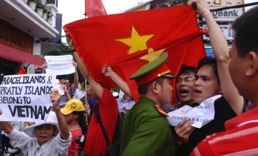 Protesters shouting anti-Chinese slogans come into confrontation with a policeman during a march in downtown Hanoi over maritime disputes. China and Vietnam have pledged to resolve the row over the strategic South China Sea, state media said, in a bid to ease tensions that prompted accusations of Chinese bullying in the region