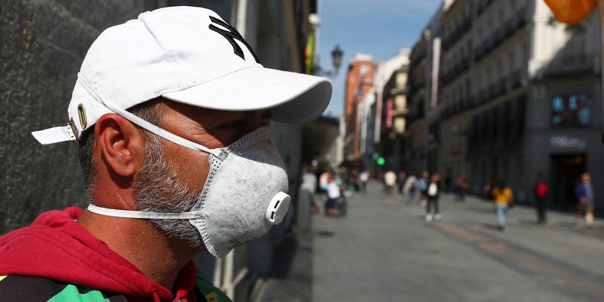 Lottery street seller Ignacio wears a protective mask as he waits for customers in unusually quiet Preciados street in central Madrid, Spain, March 13, 2020. REUTERS/Sergio Perez
