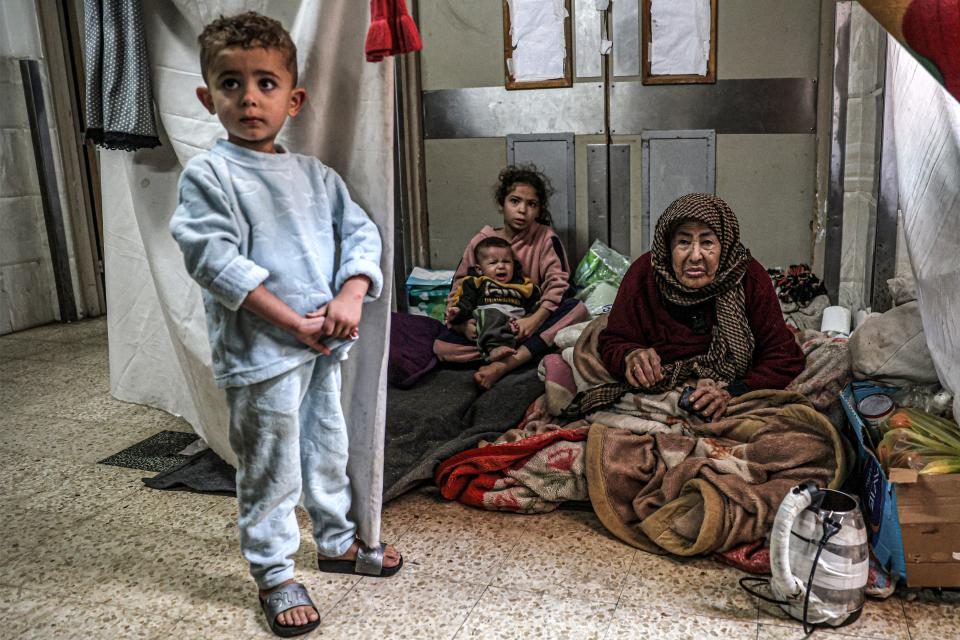 An elderly woman looks on as she sits with children at a makeshift camp in an area of the European Hospital in Khan Yunis in the southern Gaza Strip on Dec. 31, 2023, amid the ongoing conflict between Israel and the militant group Hamas.