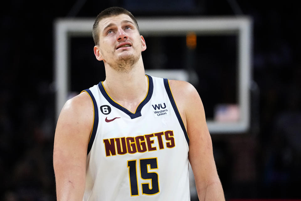 Denver Nuggets center Nikola Jokic (15) looks at the clock during the second half of Game 4 of an NBA basketball Western Conference semifinal game against the Phoenix Suns, Sunday, May 7, 2023, in Phoenix. The Suns defeated the Nuggets 129-124. (AP Photo/Matt York)