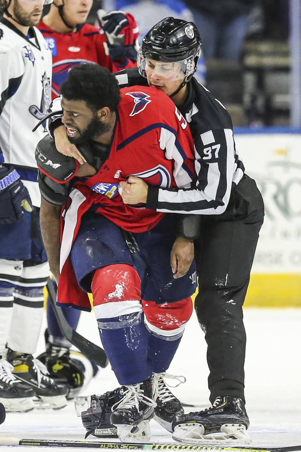 South Carolina Stingrays defenseman Jordan Subban, front left, is held by linesman Shane Gustafson after an on-ice fight during overtime of an ECHL hockey game against the Jacksonville Icemen in Jacksonville, Fla., Saturday, Jan. 22, 2022. The ECHL has suspended Jacob Panetta after the brother of longtime NHL defenseman P.K. Subban accused the Jacksonville defenseman of making “monkey gestures” in his direction. (AP Photo/Gary McCullough)