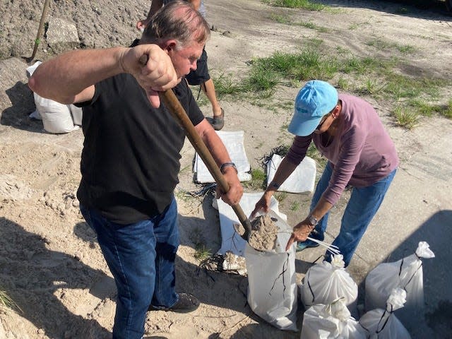 Dan Ling of Lakeland helps Barbara Larson of Mulberry load sandbags at a county distribution center in Mulberry on Monday morning in preparation for three to eight inches of rain that could be dumped on Polk County as Hurricane Ian passes this week.