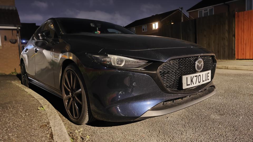 A night-time picture of a blue Mazda 3 taken with a Xiaomi 13 Pro