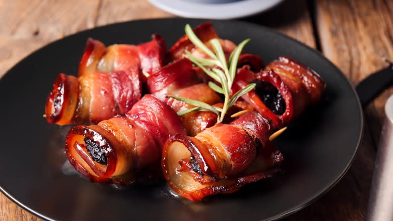 Bacon-wrapped prunes on plate