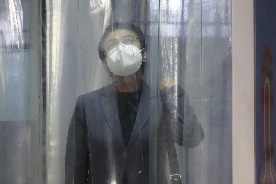Rappler CEO and Executive Editor Maria Ressa, wearing a protective mask, enters a disinfection area before attending a court hearing at Manila Regional Trial Court, Philippines on Monday June 15, 2020. Ressa's verdict is expected to be announced Monday for a cyber libel case. (AP Photo/Aaron Favila)