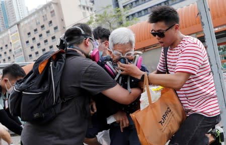 An elderly woman is helped by other demonstrators after police fired tear gas during a demonstration in support of the city-wide strike and to call for democratic reforms at Tin Shui Wai in Hong Kong