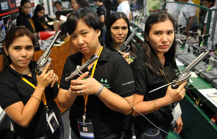 Shop assistants pose with various handgu