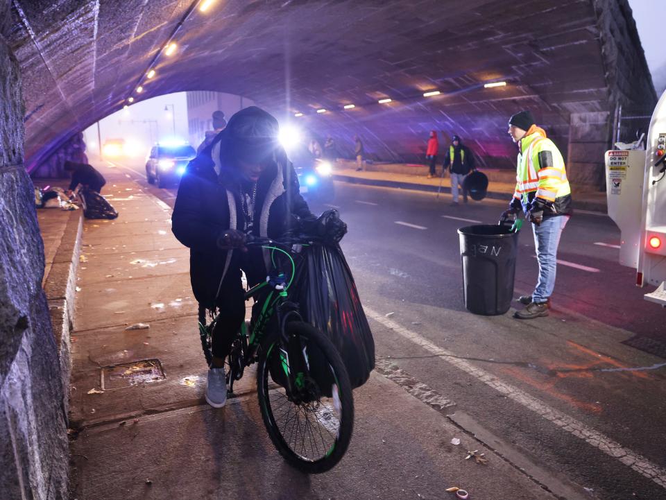 Brockton city workers clean under the School Street bridge where people who are homeless are staying on Tuesday, Dec. 26, 2023.