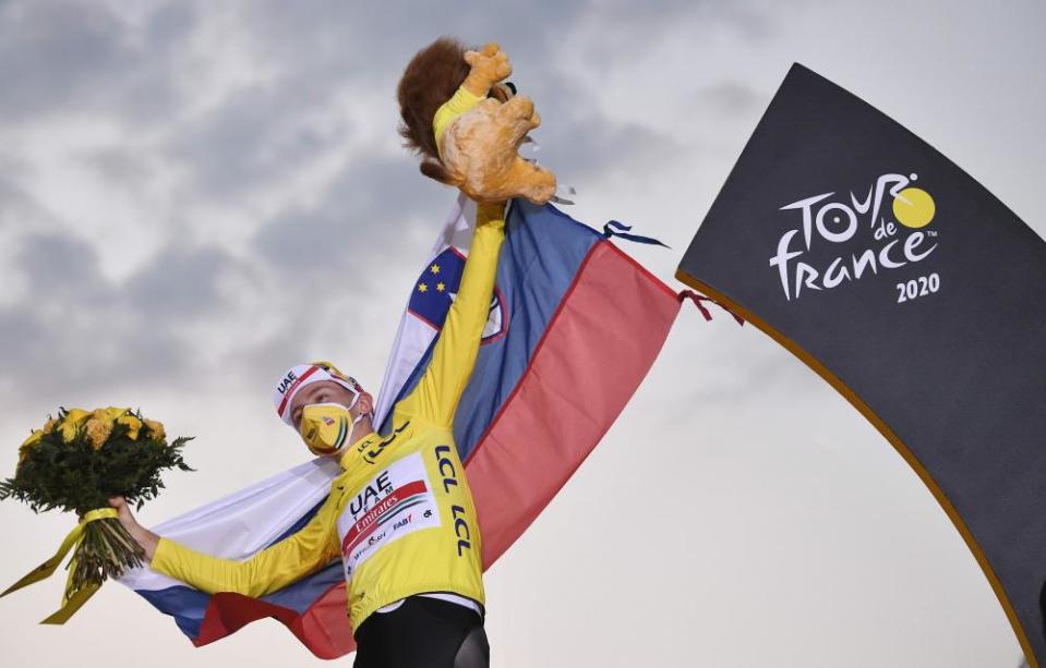 Team UAE Emirates rider Tadej Pogacar wearing the overall leader’s yellow jersey celebrates on the podium after winning the 107th edition of the Tour de France.