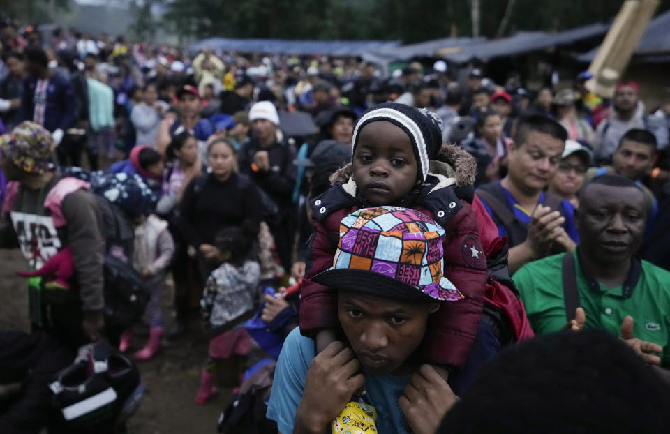 FILE - An Haitian migrant carrying a child prepares to start crossing the Darien Gap, from Colombia into Panama, in hopes of reaching the U.S., Oct. 15, 2022. (AP Photo/Fernando Vergara, File)